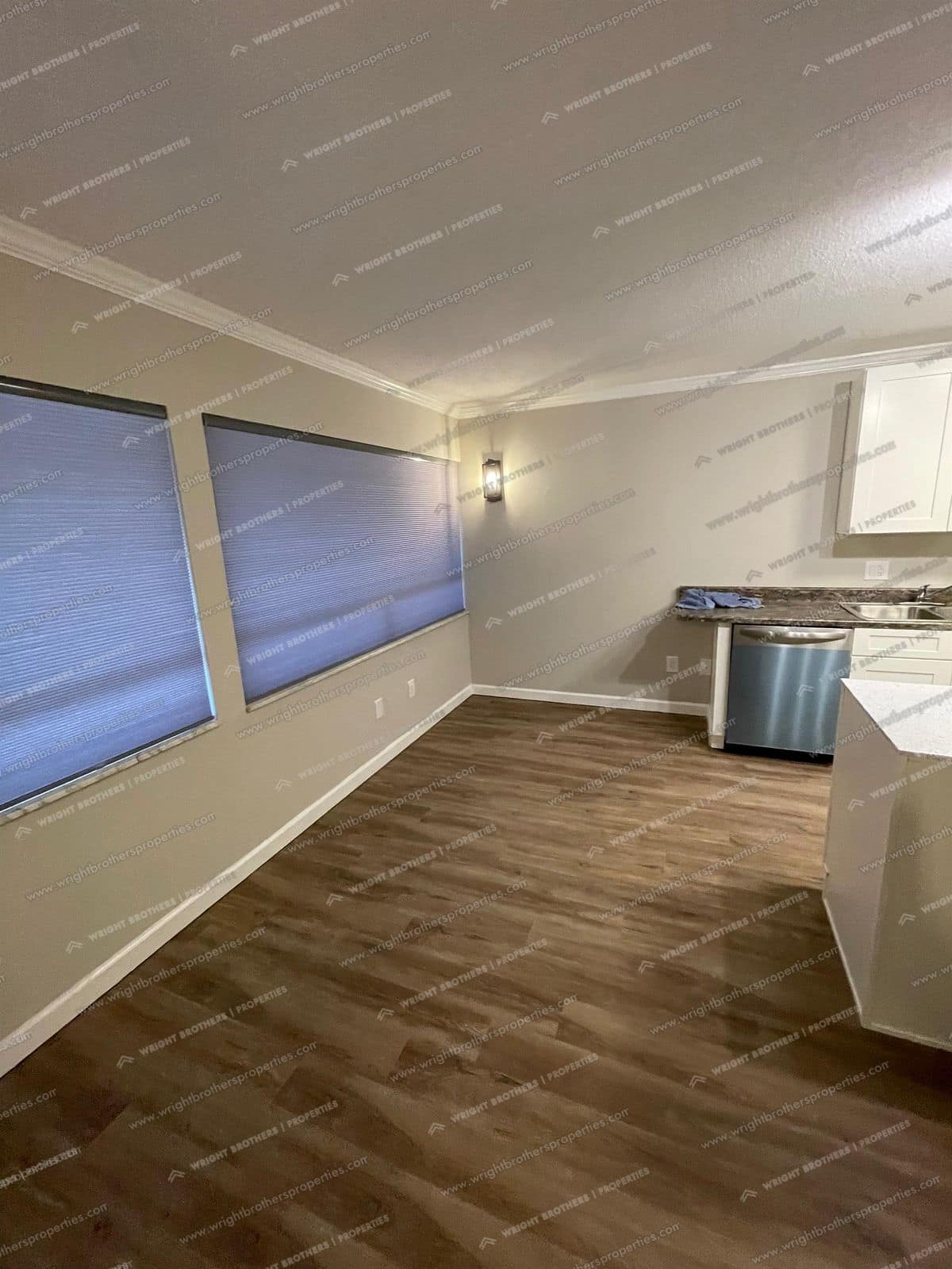 Living area with large windows, open to the kitchen